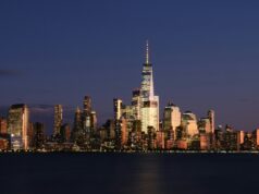 États-Unis : posséder un bien ou une entreprise ne signifie pas obtenir un statut migratoire La skyline de New York illuminée au-dessus de l’eau — États-Unis : posséder un bien ou une entreprise ne signifie pas obtenir un statut migratoire