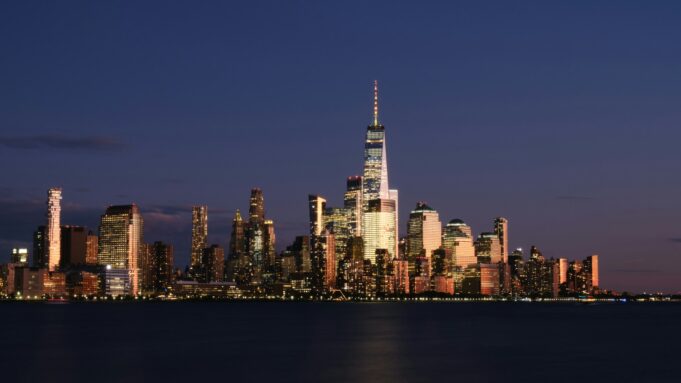 États-Unis : posséder un bien ou une entreprise ne signifie pas obtenir un statut migratoire — magazine photography La skyline de New York illuminée au-dessus de l’eau — États-Unis : posséder un bien ou une entreprise ne signifie pas obtenir un statut migratoire
