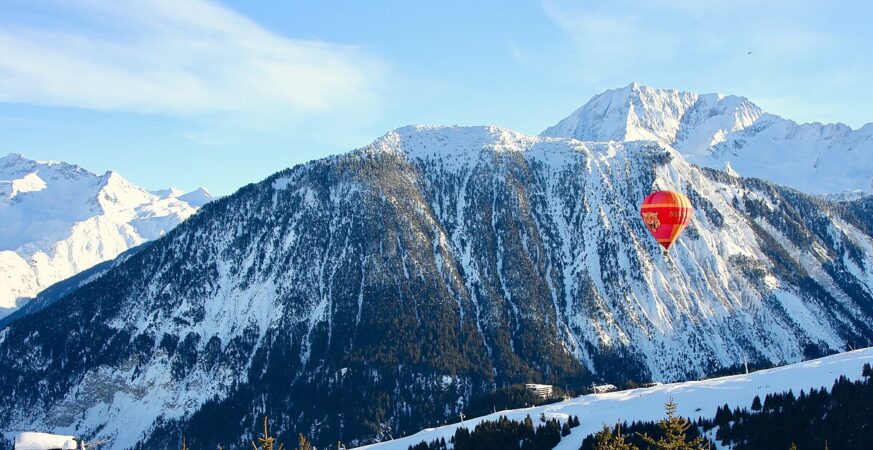 Snow-covered Alpine peaks and a red balloon seen from Courchevel
