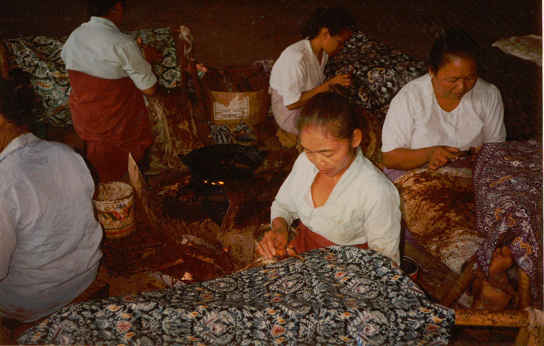 Craftswomen in Java apply wax with cantings by hand; every line protects part of the cloth from the next dye bath.