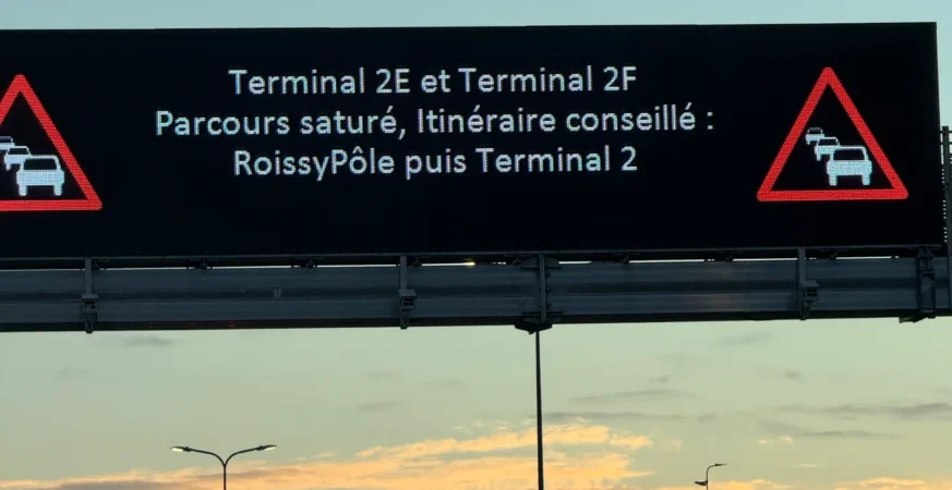 Electronic road sign warning of congestion towards Paris-CDG Terminals 2E and 2F at sunrise