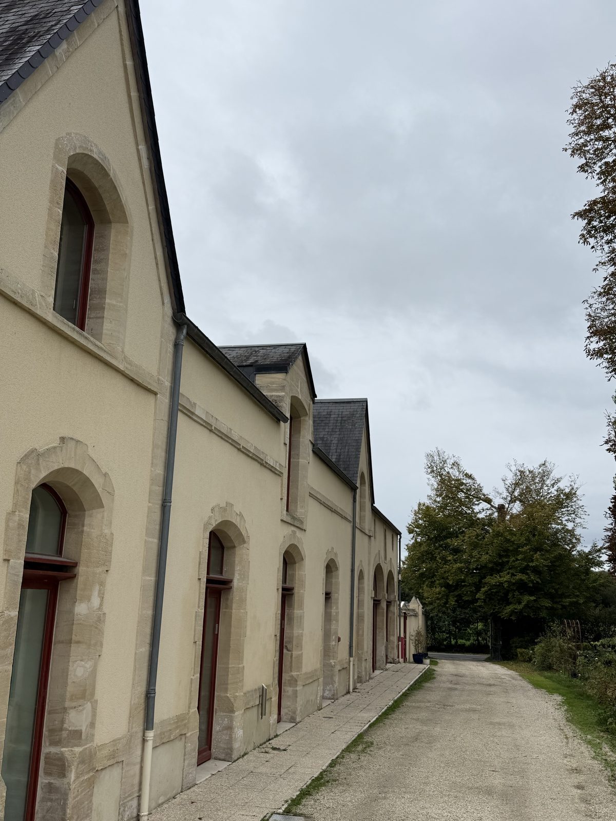Long stone annex with arched openings at Château de Bellefontaine