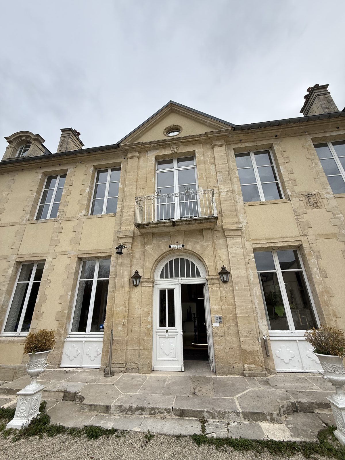 Stone entrance and symmetrical façade of Château de Bellefontaine in Bayeux