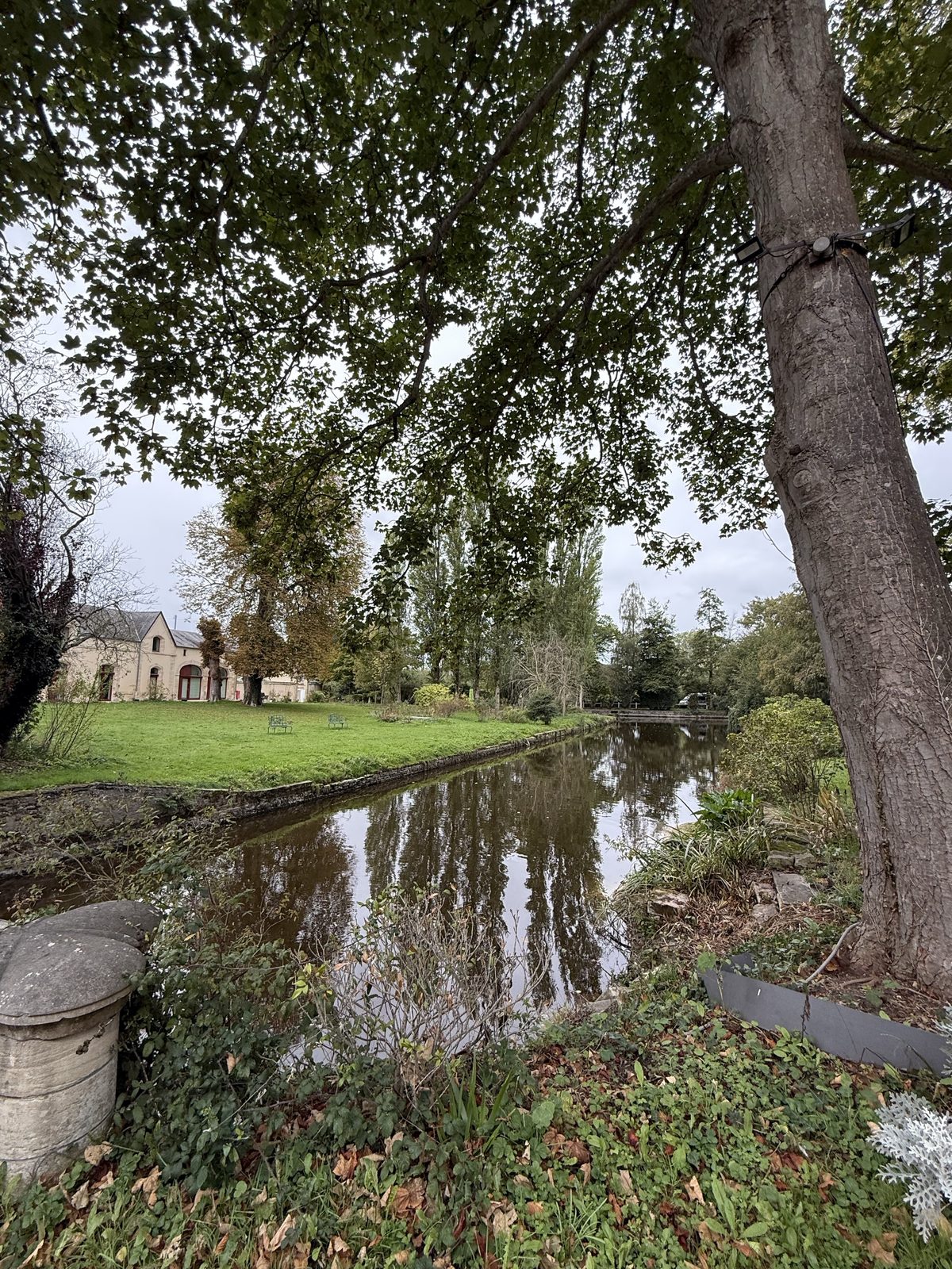 Long pond, mature trees and garden at Château de Bellefontaine in Normandy