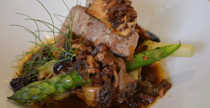 A plated fish dish with vegetables and sauce at a restaurant in France