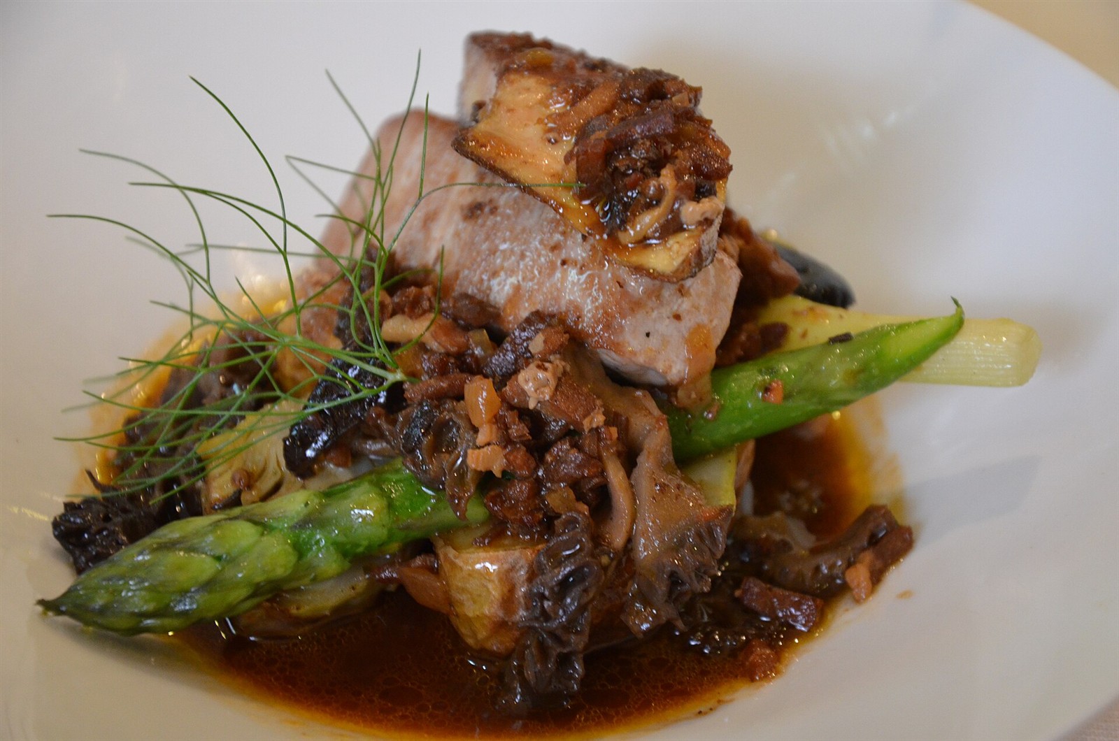 A plated fish dish with vegetables and sauce at a restaurant in France