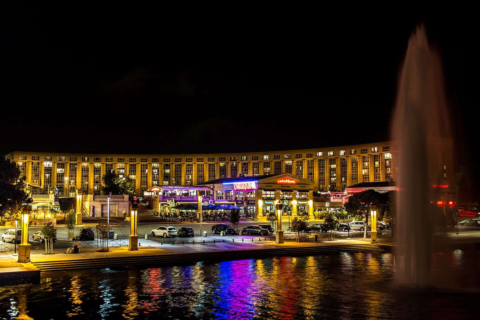 Illuminated buildings and fountain in Montpellier’s Antigone district at night