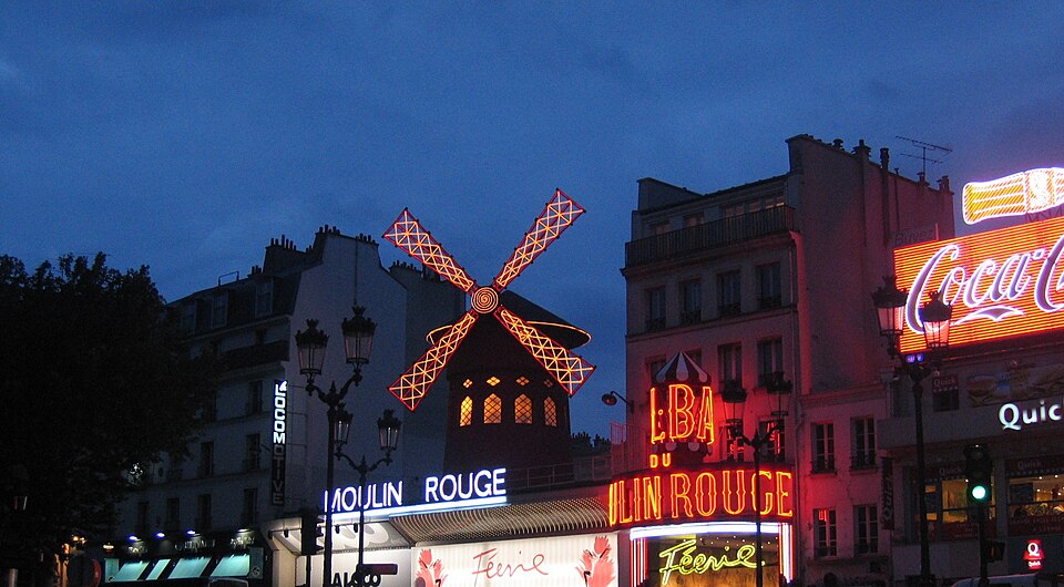 Façade rouge du Moulin Rouge illuminée la nuit à Paris