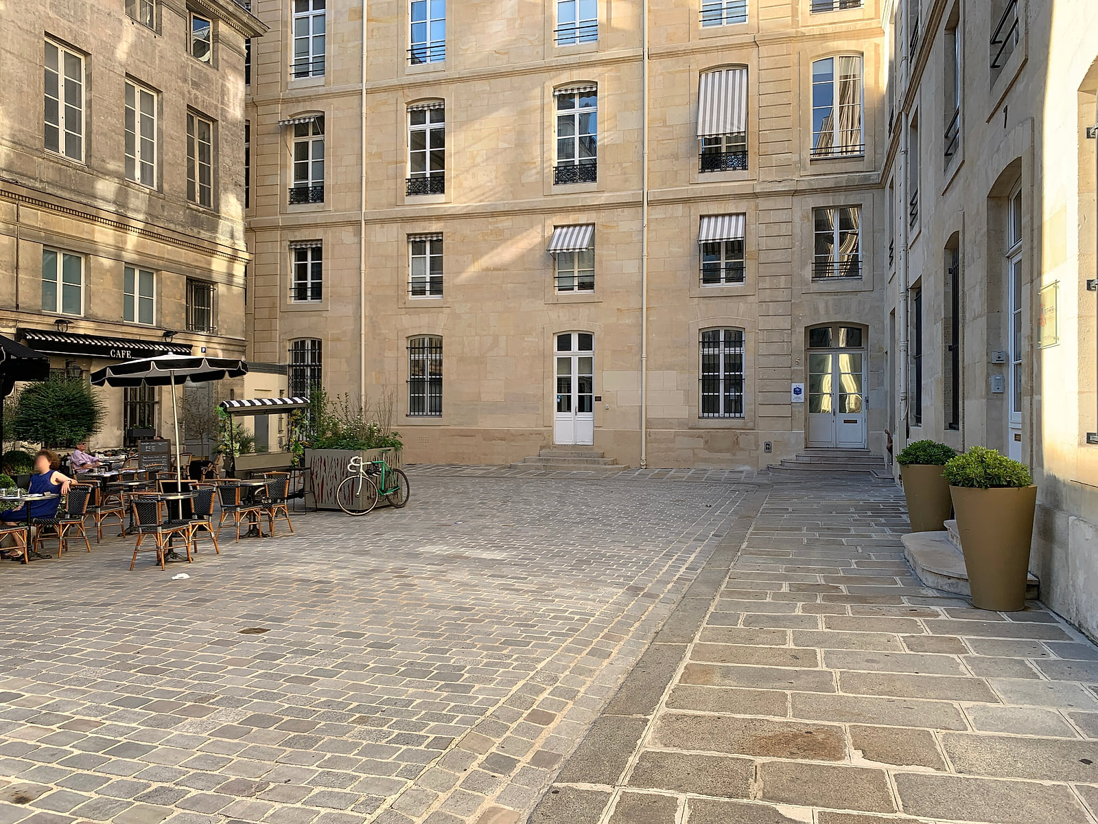 Terrasse de café calme et façades en pierre place de Valois près de l’hôtel