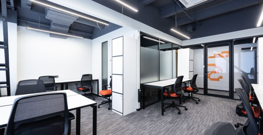 Modern workspace with desks and glass meeting rooms