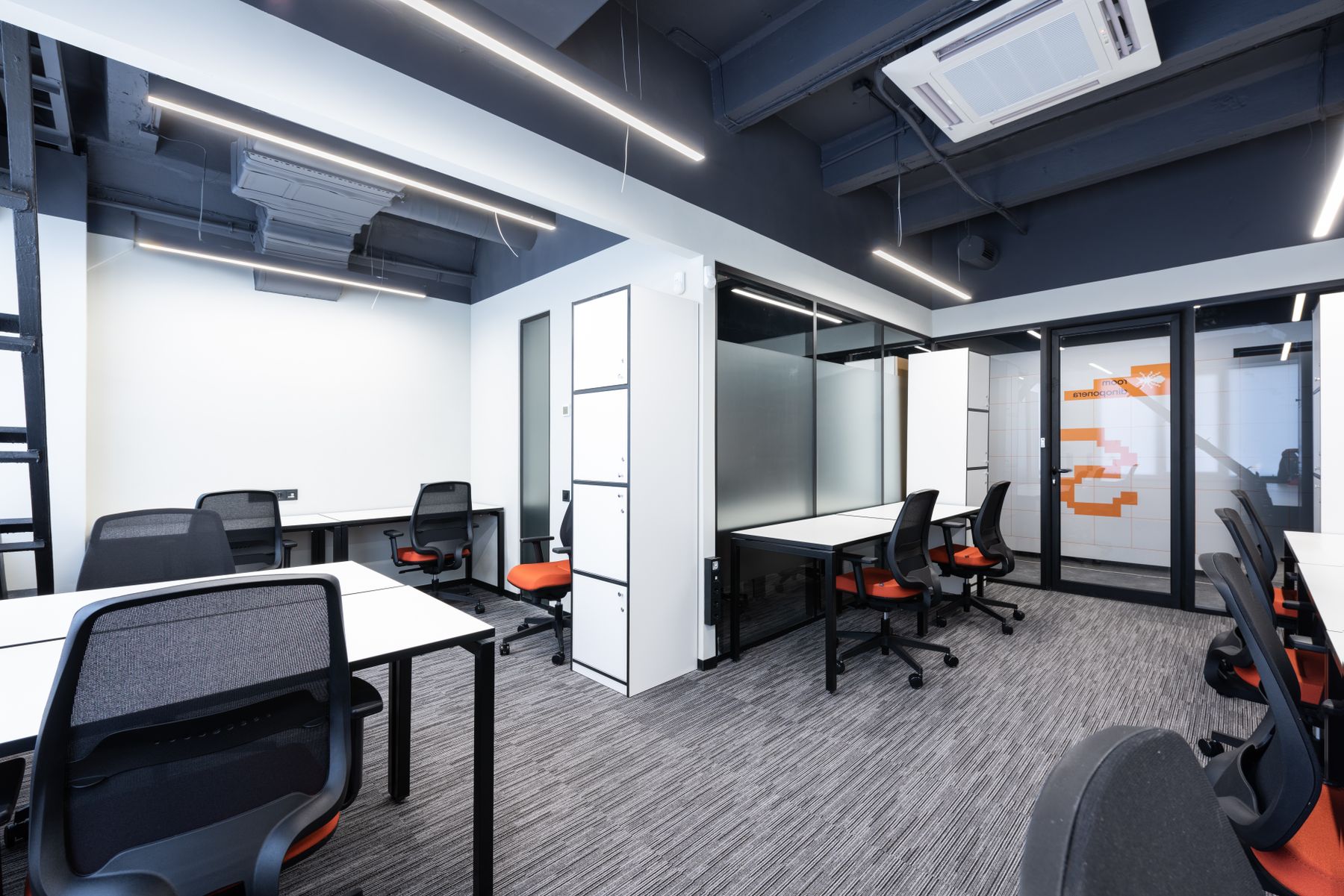 Modern workspace with desks and glass meeting rooms