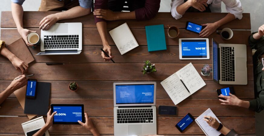 Overhead photograph of a team planning with laptops and notes