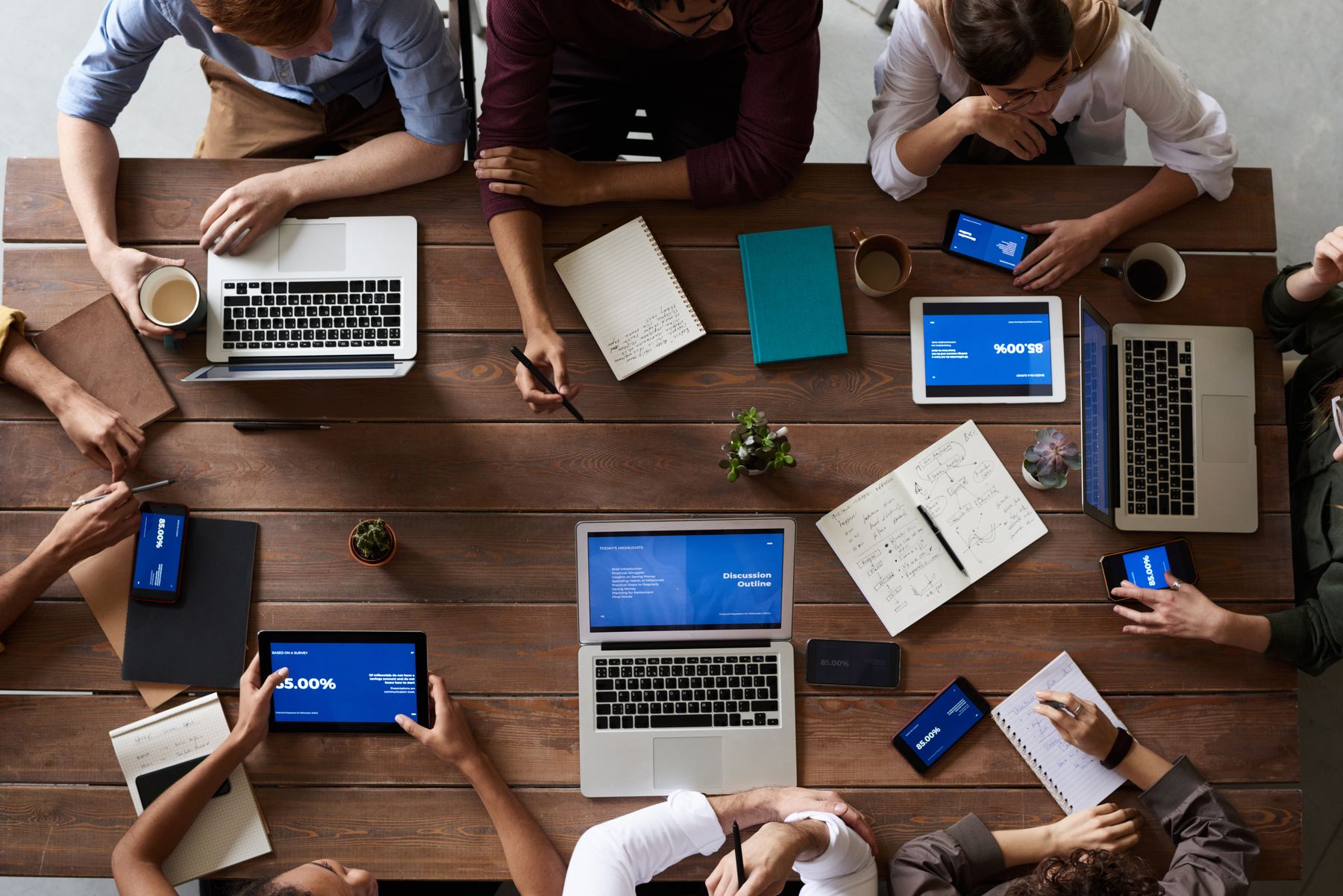 Overhead photograph of a team planning with laptops and notes