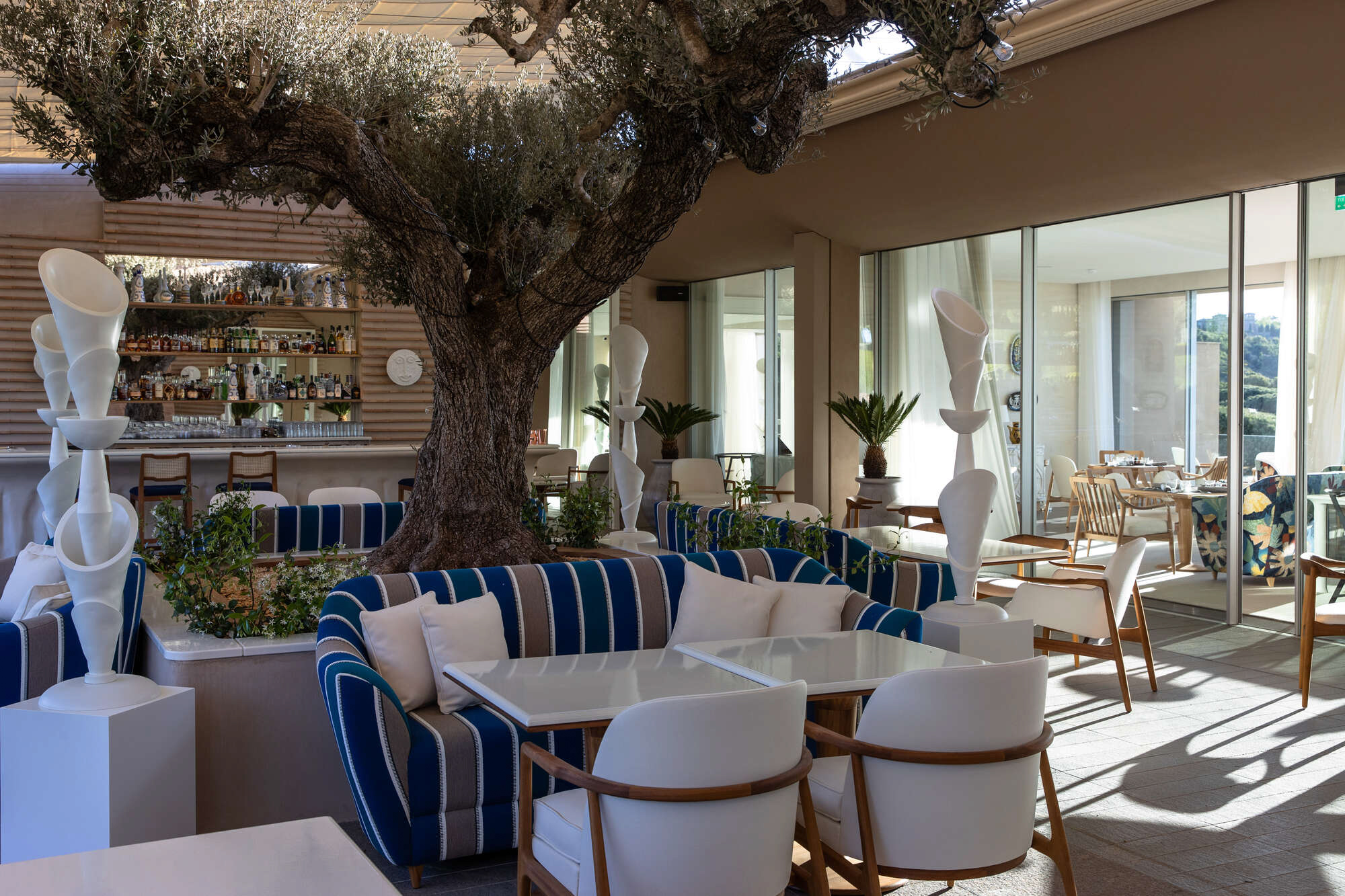 La Voile restaurant terrace arranged around an old olive tree at La Réserve Ramatuelle