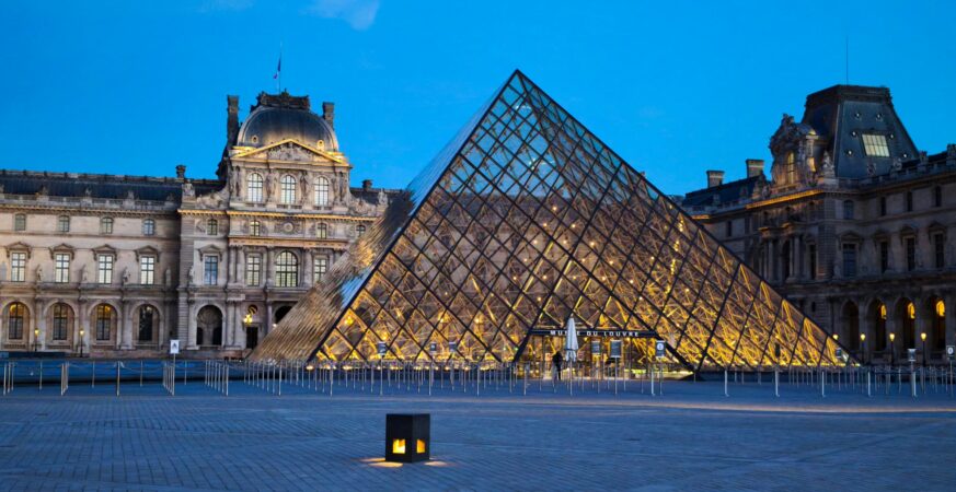 Louvre Pyramid illuminated at dusk in the Cour Napoleon, Paris