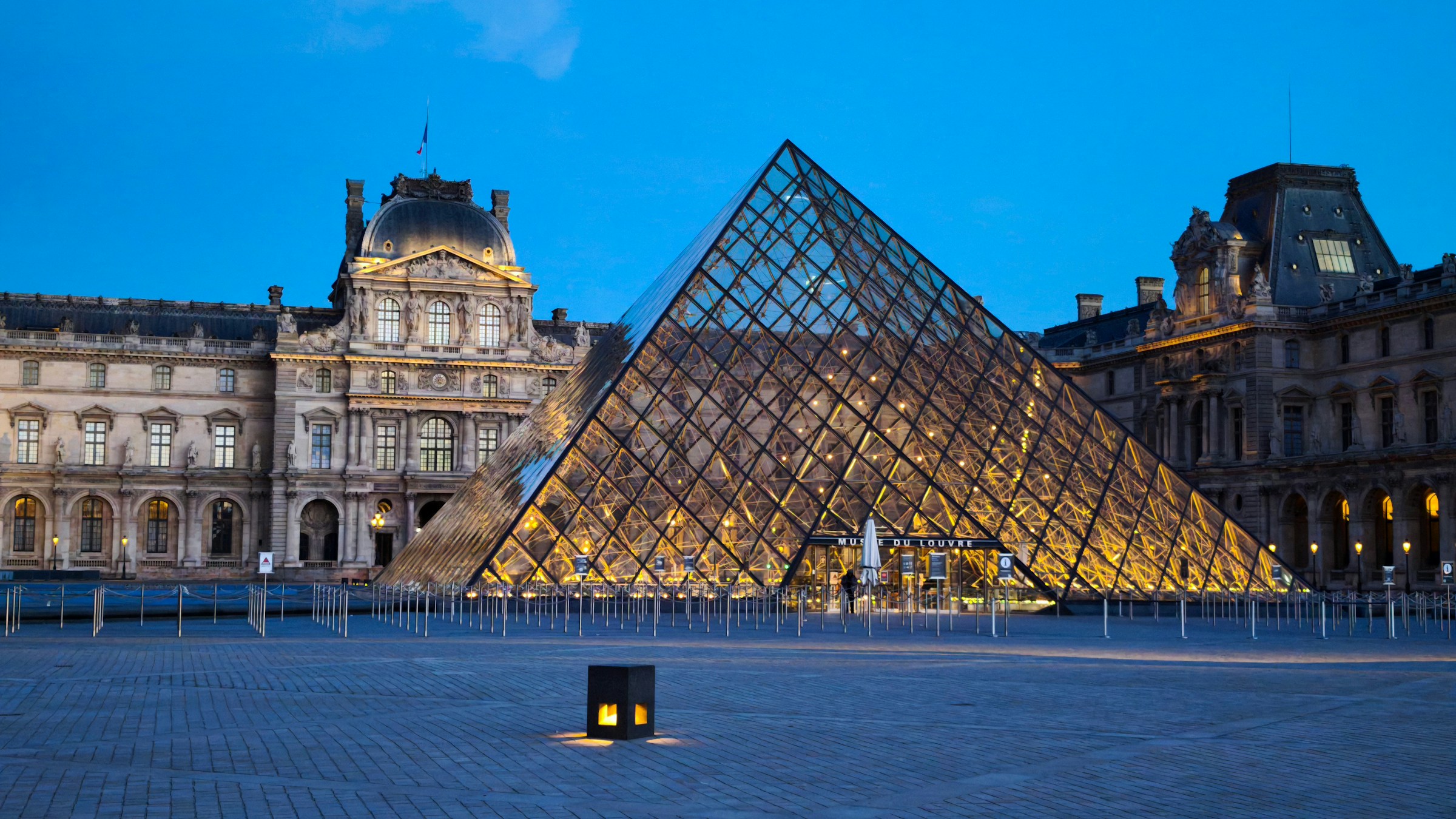 Louvre Pyramid illuminated at dusk in the Cour Napoleon, Paris