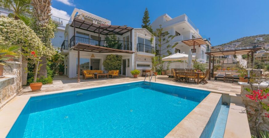 A villa with greenery and an outdoor swimming pool.