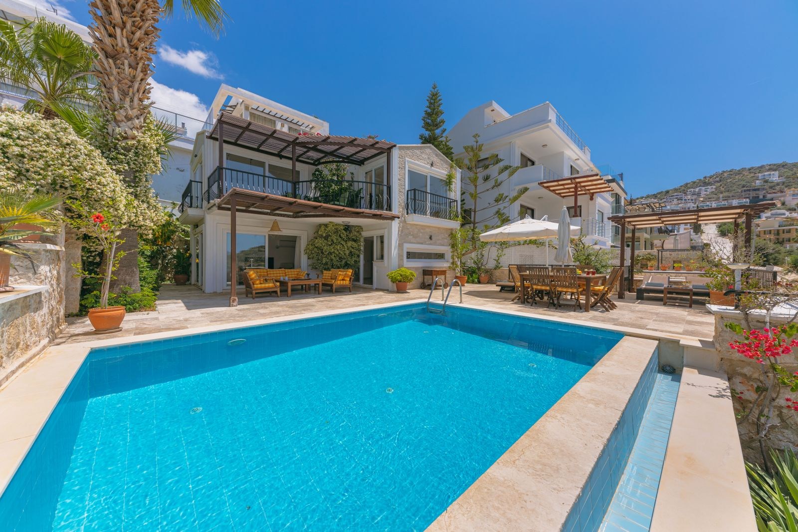 A villa with greenery and an outdoor swimming pool.