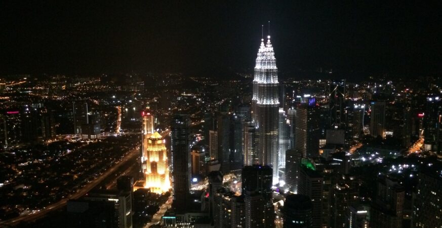 Illuminated Petronas Twin Towers and Kuala Lumpur skyline at night