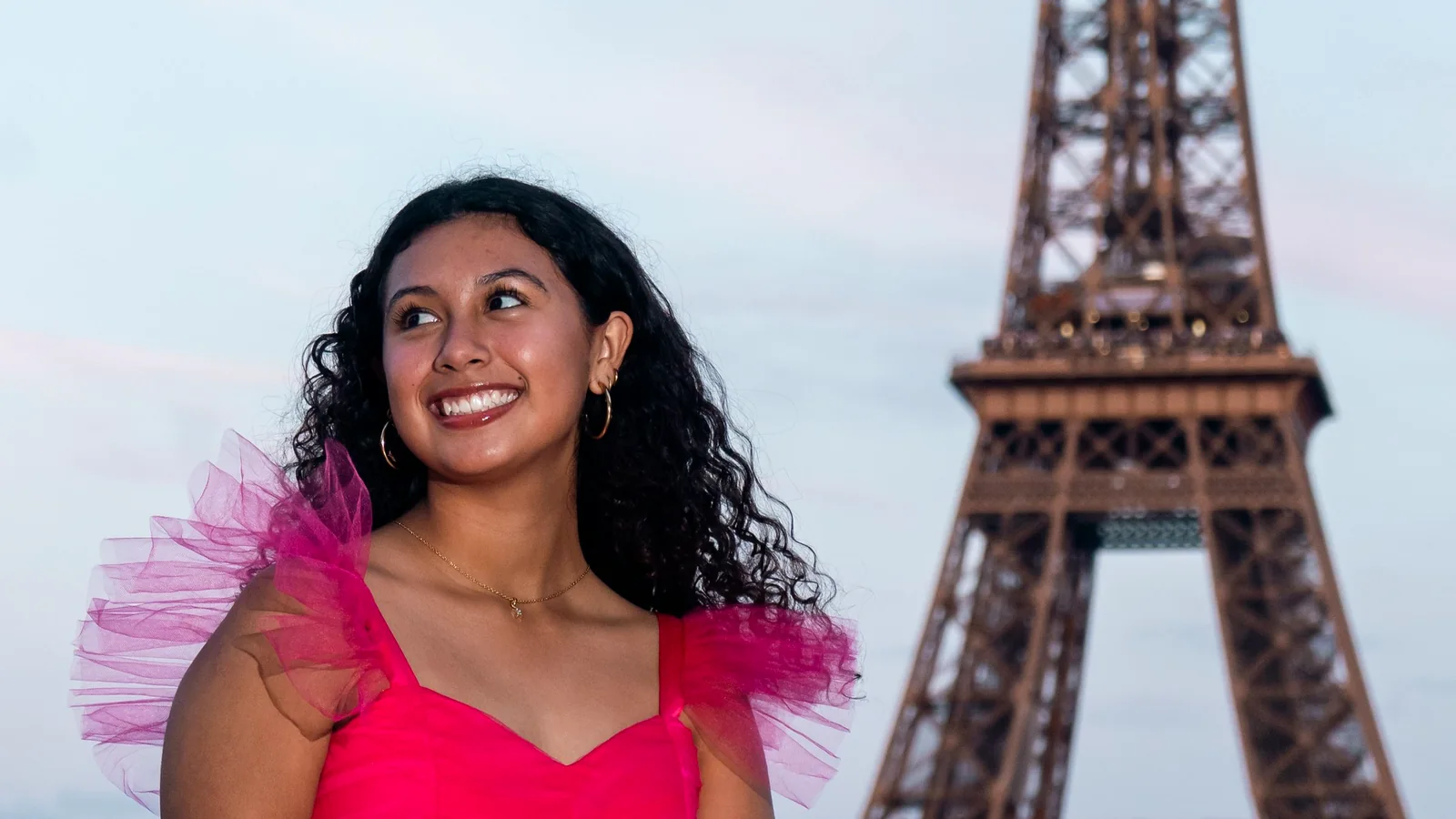 Teenager smiling in Paris with the Eiffel Tower behind her