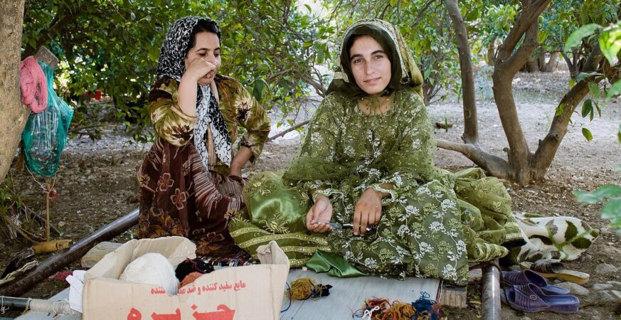 شقيقتان من القشقاي بجوار نول أفقي قرب فيروزآباد في فارس؛ وجوه الحرفة حاضرة قبل أن يظهر التصميم كاملًا.
