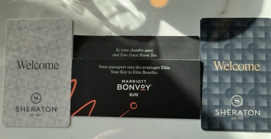 Two Sheraton room key cards and a Marriott Bonvoy sleeve on a table
