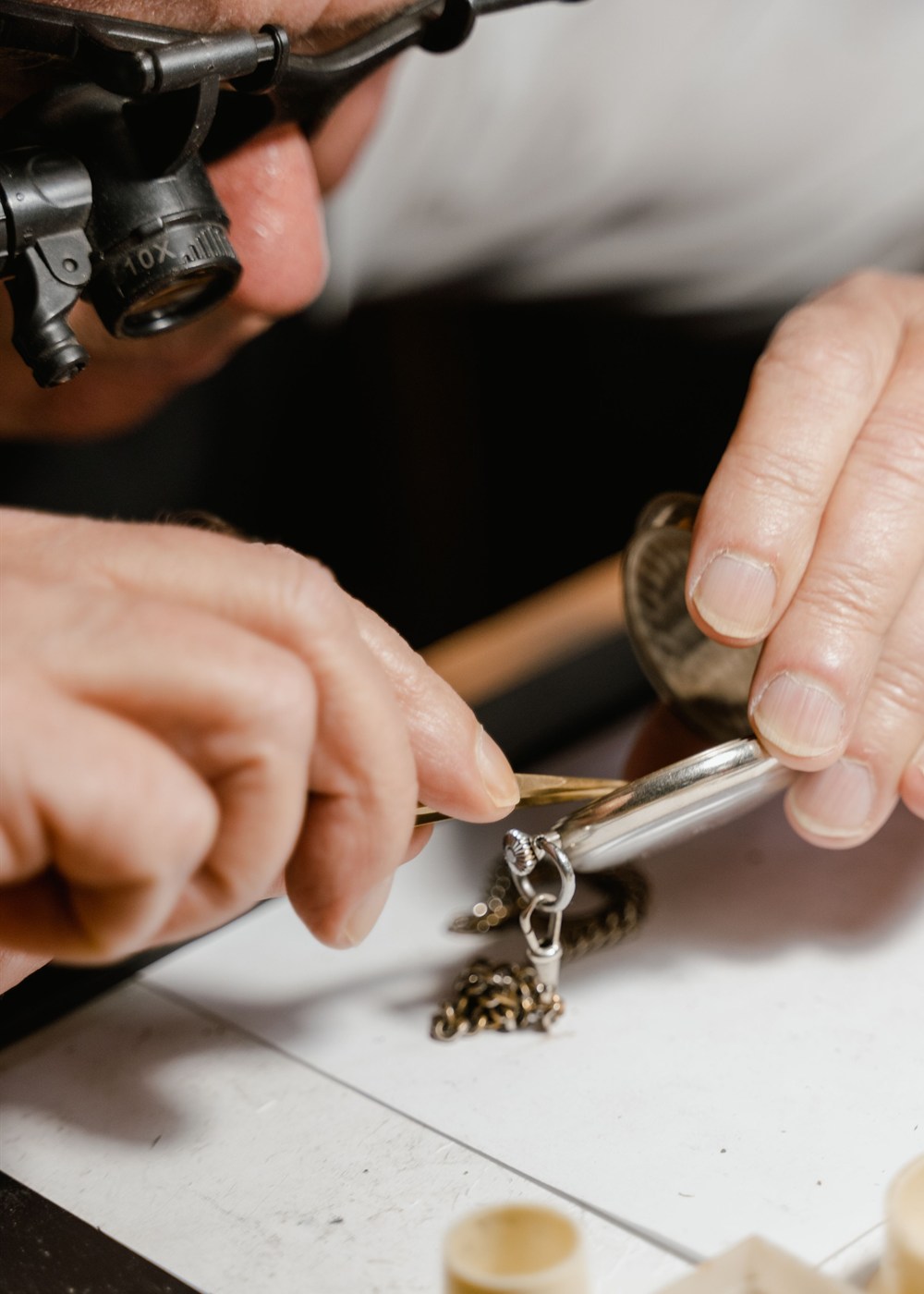 Loupe, tweezers and pocket watch: repair begins with diagnosis and the minimum necessary intervention, not the replacement of everything old.