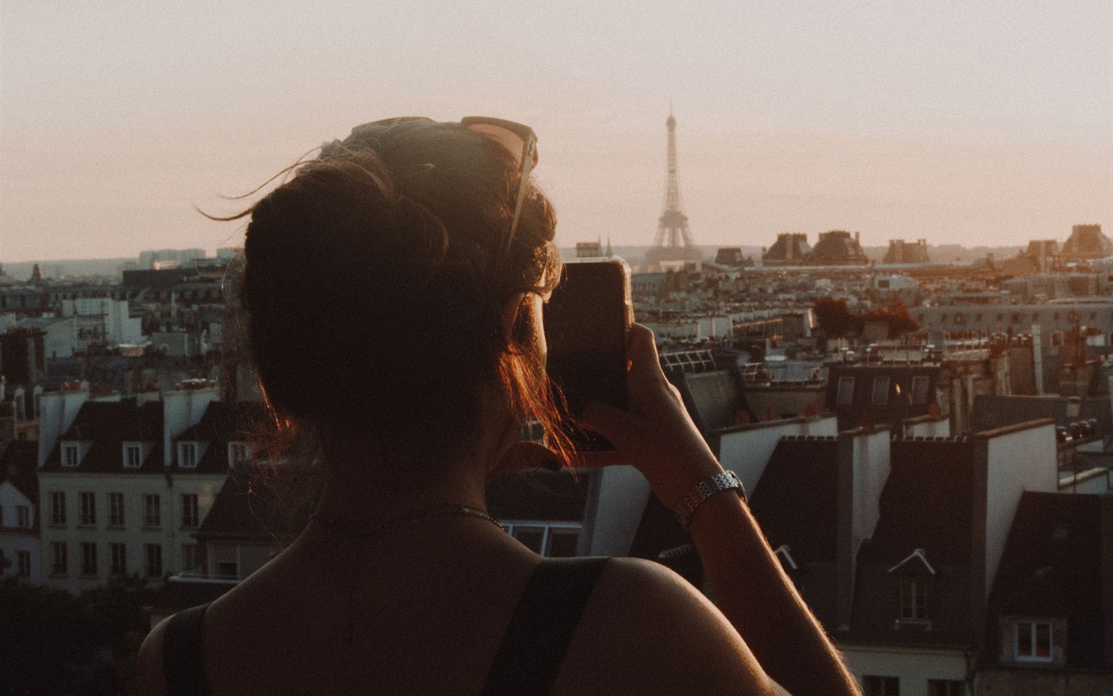 Un smartphone face à la tour Eiffel au coucher du soleil — photographie d’archives.